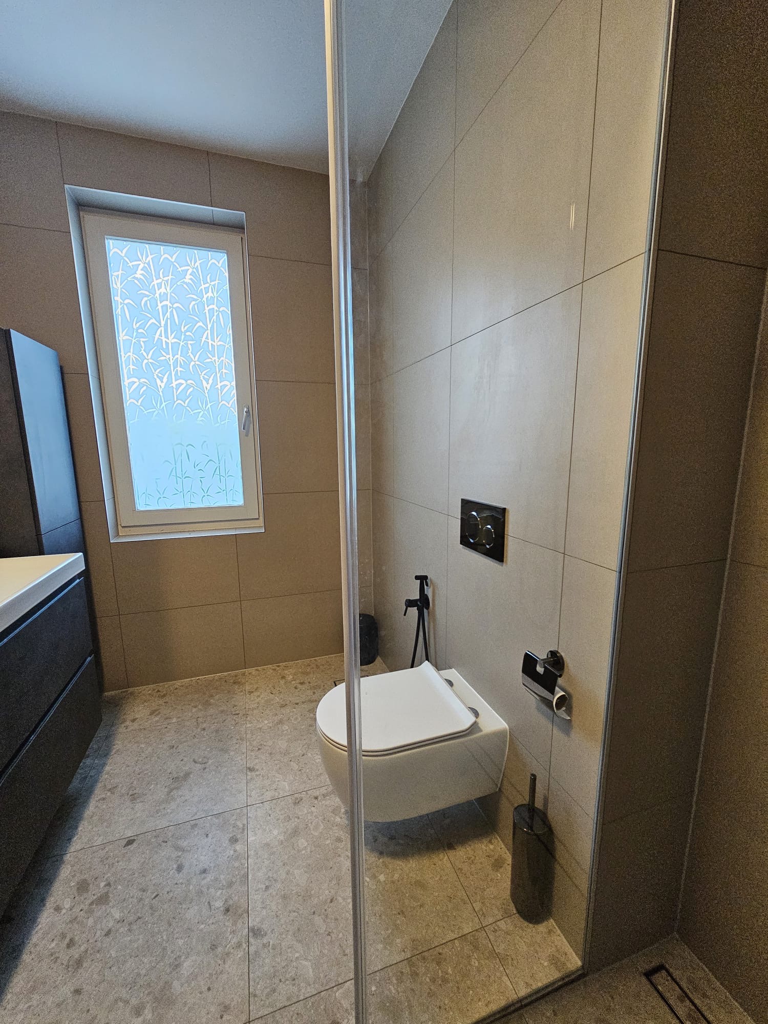 Toilet en douchewand met grootformaat wandtegels