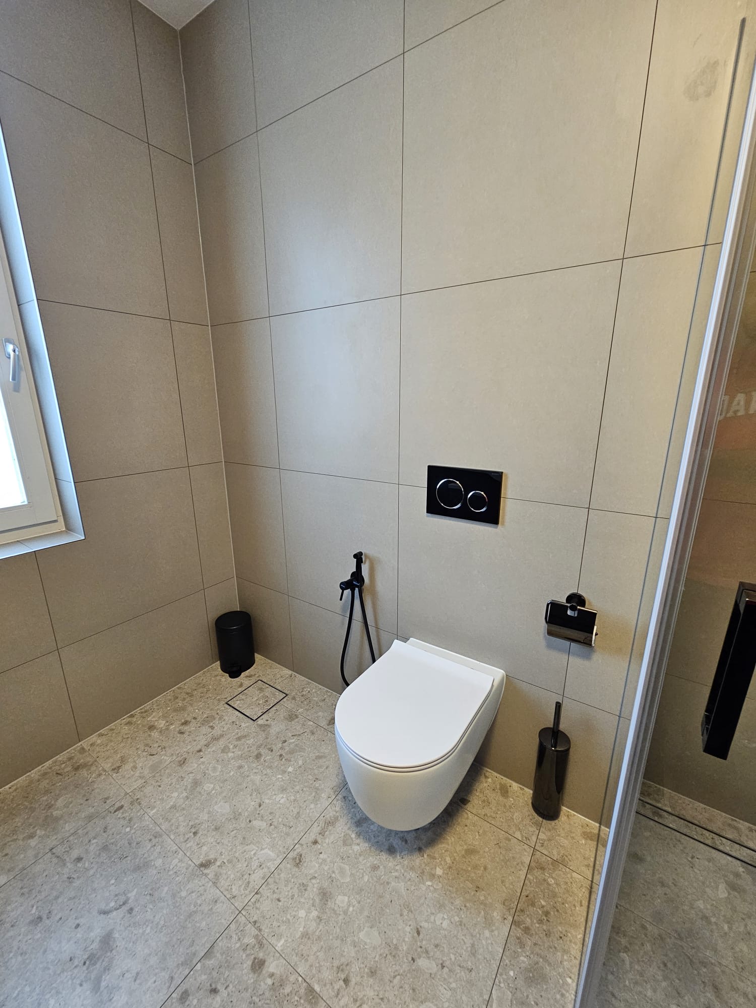 Hangtoilet met bidetkraan en natuursteenlook vloertegels