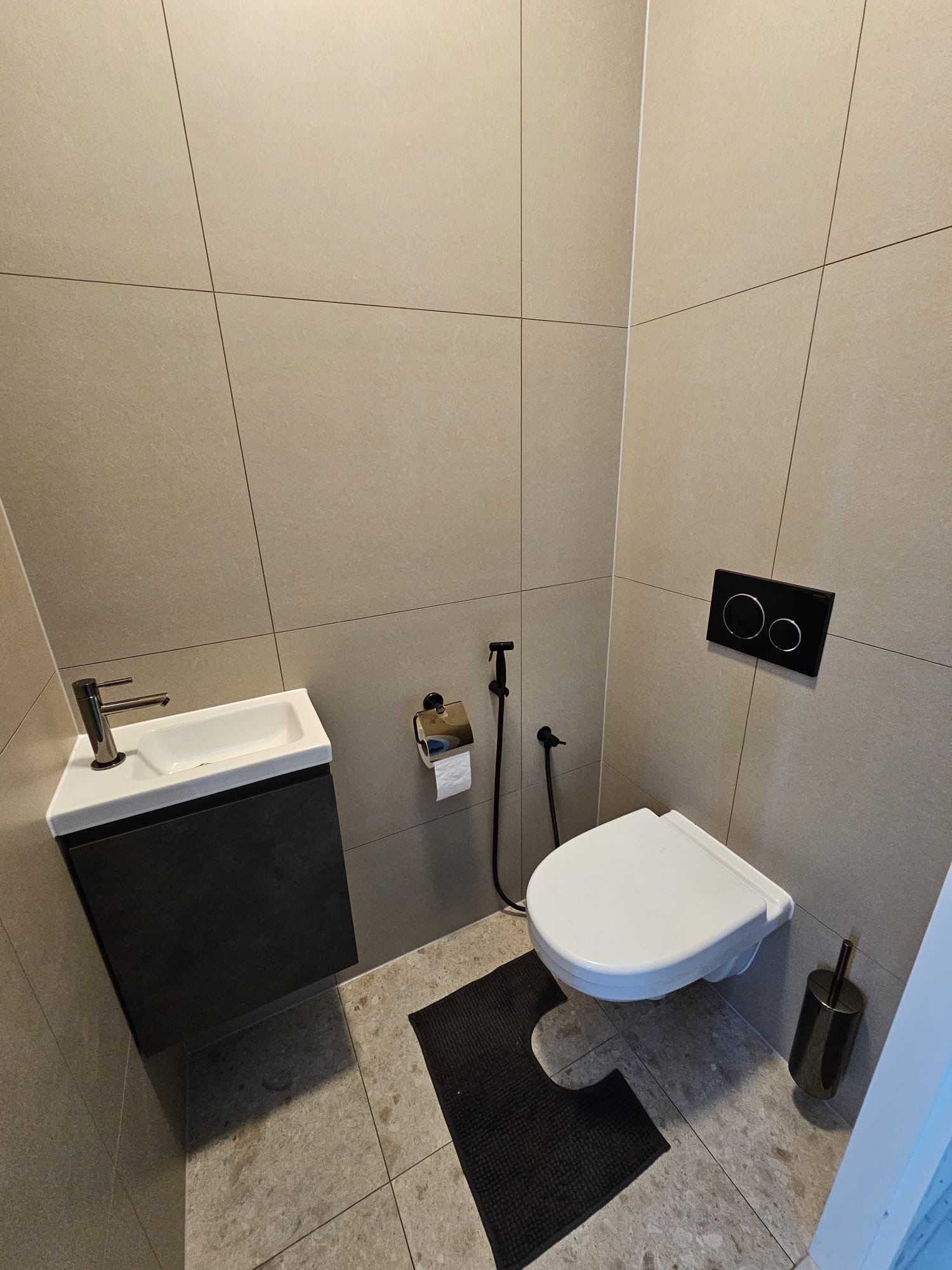Toiletruimte met fonteintje en wandcloset na renovatie